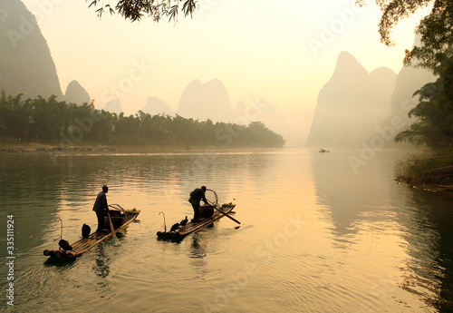 Sylwetka Dwa połowu mężczyzna i Jego kormoranów na Li rzece przy wschodem słońca, Guilin, Chiny. Rzeka Li lub Lijiang to rzeka w regionie autonomicznym Guangxi Zhuang w Chinach.