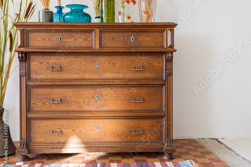 old antique old mahogany chest of drawers in a room with additional decor. interesting design
