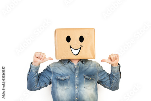 Hombre divertido con caja de cartón en la cabeza con cara sonriente sobre fondo blanco. Vista de frente. Copy space 