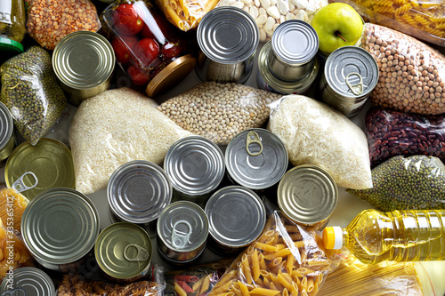 Set of raw cereals, grains, pasta and canned food on the table.