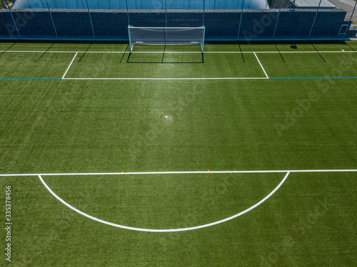 Aerial view of football goal and penalty area. Empty soccer field with white lines.