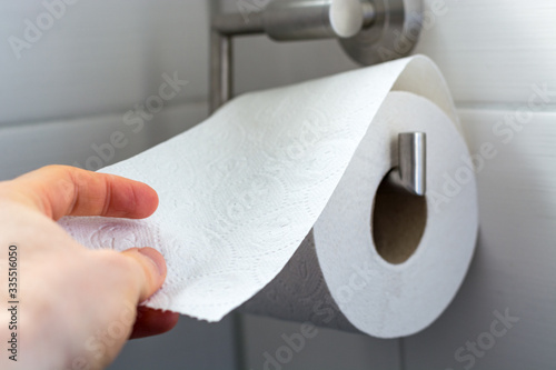 Man grabs toilet paper as a close up