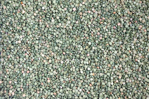 Food supplies. Crop of many dry green green peases grains on flat surface as background top view close up