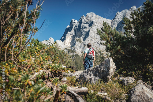 Hiker looking at an impressive alpine rockface.