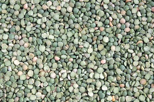 Food supplies. Crop of many dry green green peases grains on flat surface as background top view close up