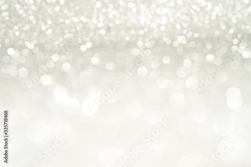 silver Sparkling Lights Festive background with texture. Abstract Christmas twinkled bright bokeh defocused and Falling stars. Winter Card or invitation.