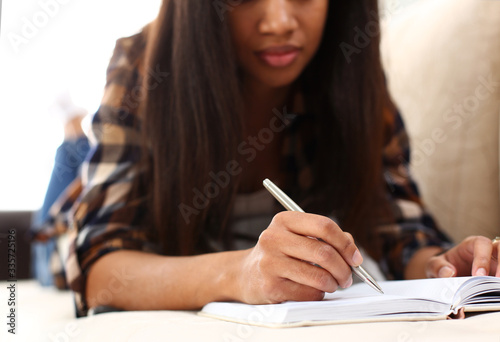 Arm of black woman write story in notebook preparing for college