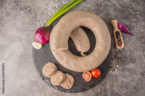 Homemade liver sausage on black slate, a few pieces cut, with spices, top view