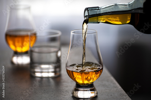 Pouring in tulip-shaped tasting glass Scotch single malt or blended whisky