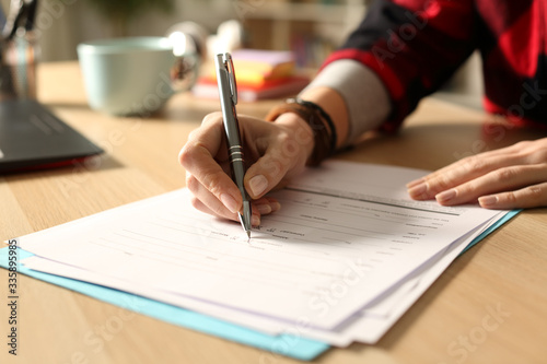 Student girl hand filling out form at night