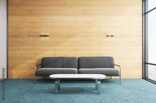 Minimalistic waiting room with sofa and blank wooden wall.