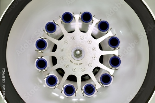 Laboratory open centrifuge with empty test tube compartments. View from above.