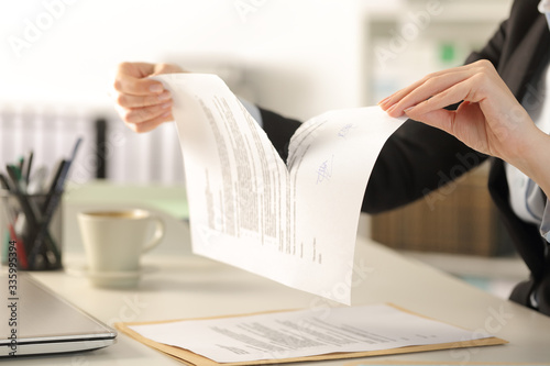 Business woman hands breaking document at the office