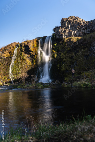 Waterfall Gjain in a scenic valley during sunny day in Iceland