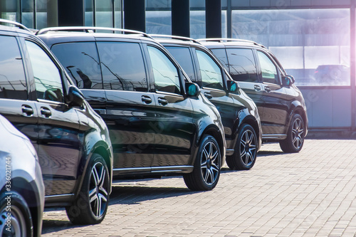 Dark colored passenger vans in a parking lot.