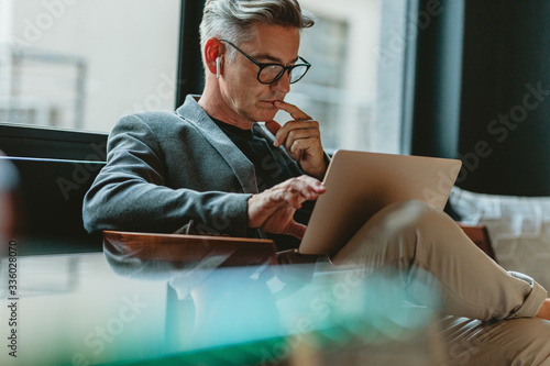 Businessman reading emails in office lobby