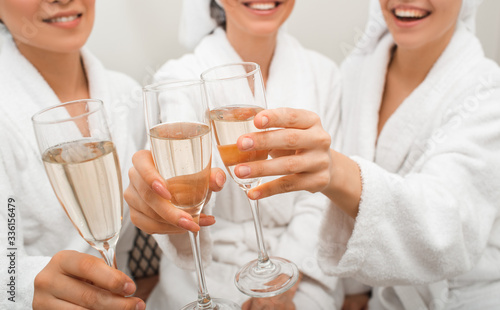 Clink glasses with champagne. Close-up of drinks in the hands of women relaxing in a spa