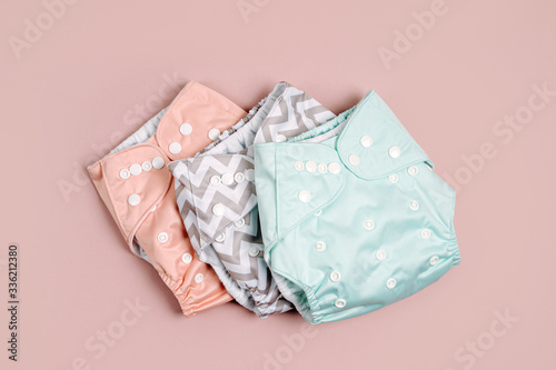 Reusable cloth baby diapers. Eco friendly cloth nappies on a pink background. Sustainable lifestyle. Zero waste concept.