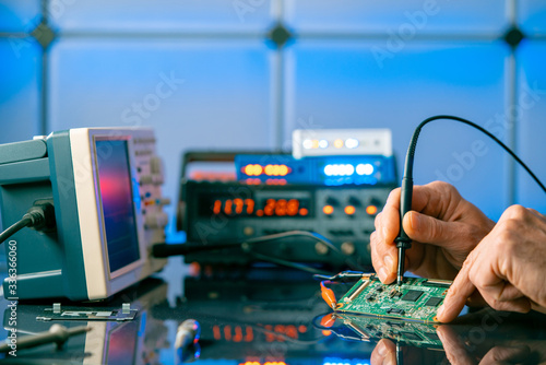 Debugging electronics device. PCB witch microcontroller in electronics laboratory