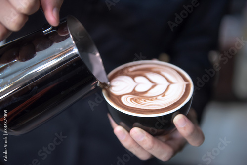 Barista make latte art in coffee cup at coffee shop cafe