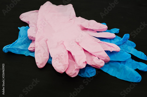 blue and pink gloves on a black background. Medical gloves.