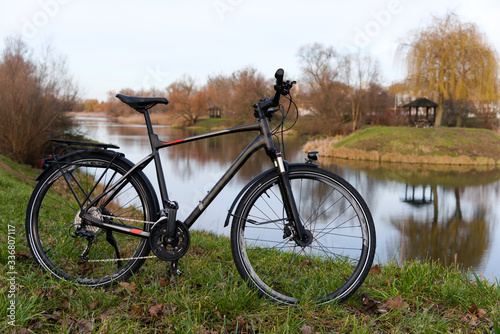 A new tourist bike standing on the shore of the lake.