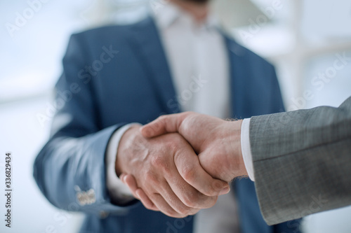 business partners greet each other standing in the office