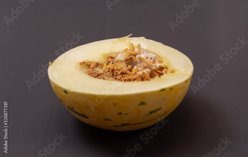 Melon fruit (Cucumis mello L.) halved on a dark background