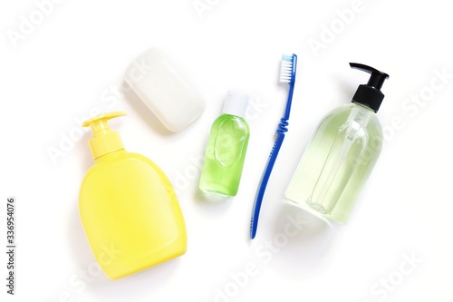 Soap packing, sanitizer gel in green bottle and toothbrush. Cosmetic products, toiletries for hygiene