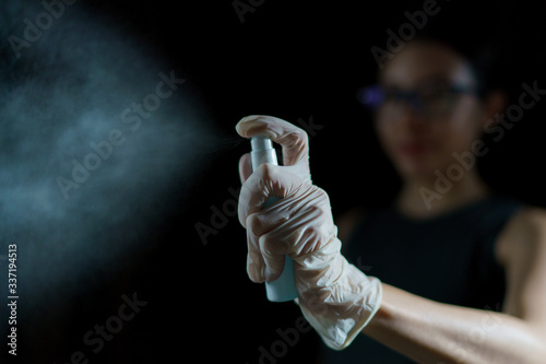 Woman Hand using sanitizer spray, alcohol spraying disinfectant to stop spreading coronavirus or COVID-19.