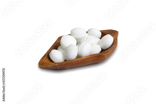 White naphthalene balls in a wooden bowl isolated on a white background.