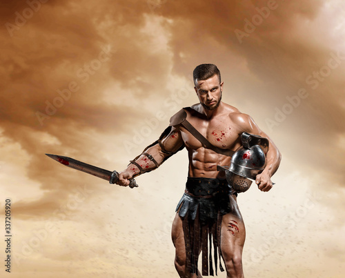 Gladiator fighting on the arena of the Colosseum on dramatic light. Roman Hoplomachus armed fighter Concept historical photo