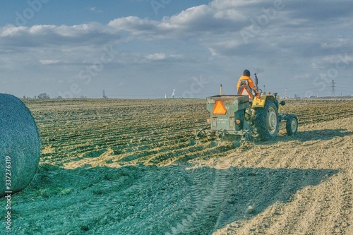 traktor sadzący ziemniaki, wiosna na polach, prace polowe wiosną, rządki posadzonych ziemniaków, słoneczna wiosenna pogoda