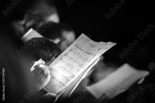 Hand holding music score in choir