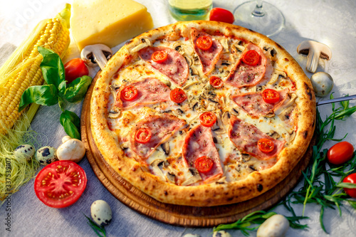 Delicious italian pizza served on table with ingredients cheese and vegetables