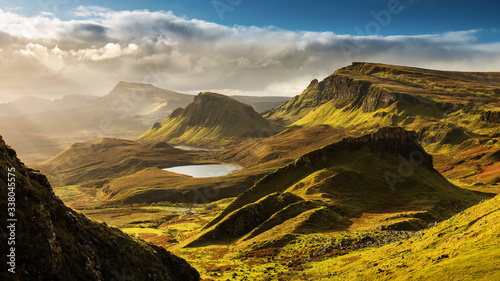 Scenic view of Quiraing mountains in Isle of Skye, Scottish highlands, United Kingdom. Sunrise time with colourful an rayini clouds in background.