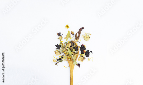 herbal tea leaves with wooden spoon on white background isolated