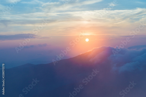 sunset in the mountains, mountains in the clouds in a haze