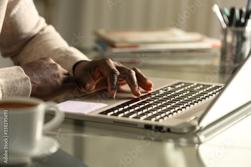 Black man hand using touchpad on laptop at night