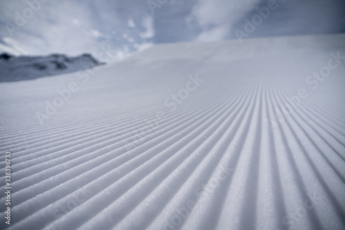 Pattern of a freshly groomed ski slope in front of a big kicker in a snowpark in St.Anton.