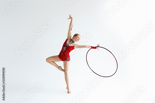 Gymnastics performance. Motivated sportswoman with hoop training to become champion, white background