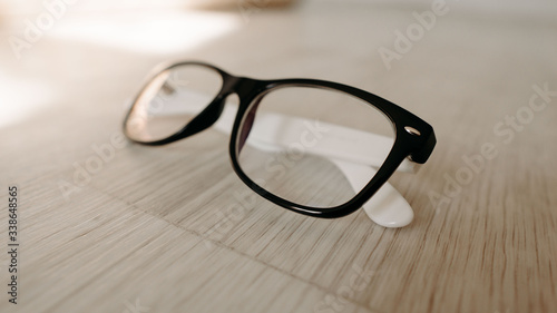 glasses on a wooden table. hipster glasses on a wooden floor. glasses for vision. white wood 