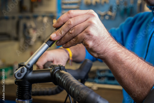 Tightening of a bicycle handlebar stem with the use of a small torque wrench. Proper way to tighten a bicycle stem. Bicycle service in a worshop.