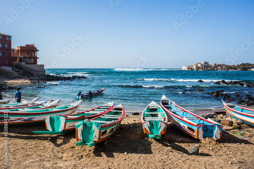 Fishing boats in Ngor Dakar, Senegal, called pirogue or piragua or piraga. Colorful boats used by fishermen standing in the bay of Ngor on a sunny day.
