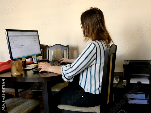 Kobieta pracująca zdalnie w domu przed komputerem