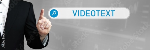 Videotext. Mann im Anzug zeigt mit dem Finger auf ein Suchfeld. Das Wort Videotext steht in der Suche. Symbol für Business, Finanzen, Statistik, Analyse, Wirtschaft