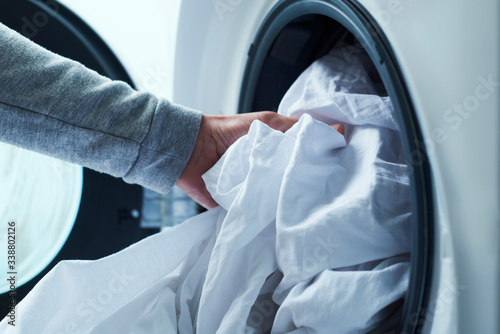 man putting clothes into the washing machine