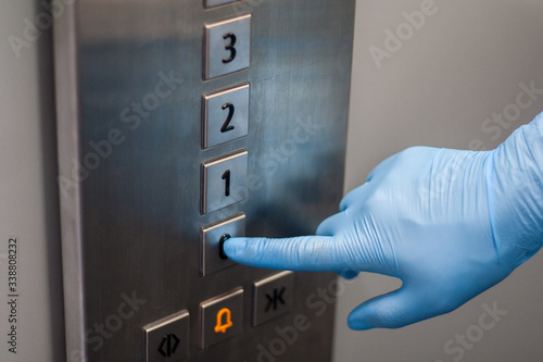 Przyciskanie przycisku w windzie ręka w rękawiczce