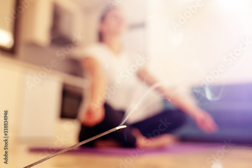 Close-up of breathing meditation, incense stick on the background of a person who practices yoga