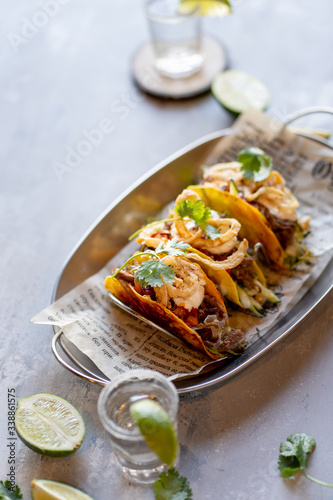 Mexican meat tacos with tequila shots on stone background